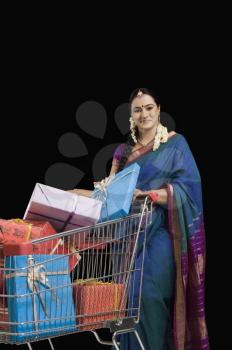 Woman carrying Diwali gifts in a shopping cart