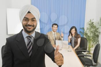 Business executives showing thumbs up and smiling