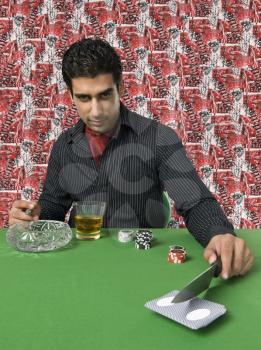 Man smoking and drinking at a casino table