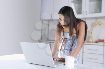 Woman using a laptop in the kitchen