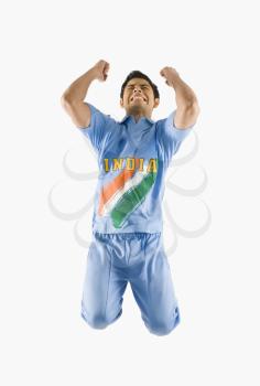 Cricket bowler celebrating with his arms raised
