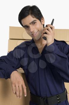 Store incharge talking on a walkie-talkie in a warehouse