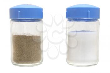 Black ground pepper and salt in banks on a white background.                    