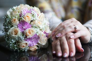 Royalty Free Photo of a Woman's Hands Beside a Bouquet
