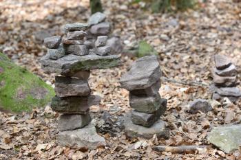 A small cairn made by tourists in the forest against a background of trees