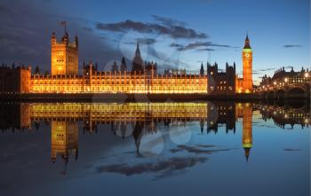 Big Ben and Houses of Parliament (Westminster Palace) in London reflected in River Thames at night