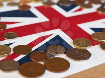 Pound coins money (GBP), currency of United Kingdom, over the Union Jack