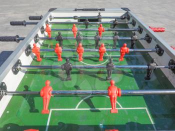 Table football aka table soccer, foosball from the German Tischfussball, baby-foot or kicker table-top game and sport