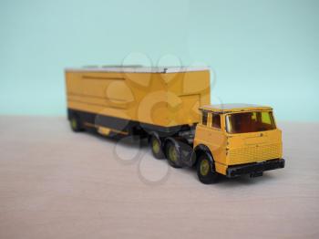 Vintage scale model yellow lorry with selective focus. Articulated vehicle with tractor and trailer.