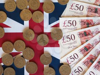 Pound coins and banknotes money (GBP), currency of United Kingdom, over the Union Jack