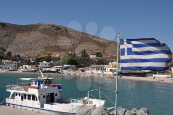 Royalty Free Photo of the Bay of Pserimos Island with Greece Flag