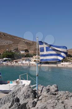 Royalty Free Photo of the Bay of Pserimos Island with Greece Flag
