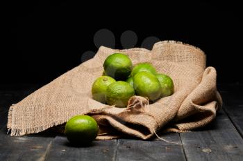Green limes on brown bag on a table