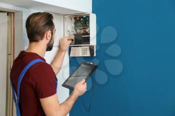 Electrician inspecting alarm system�
