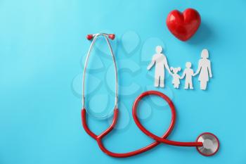 Family figure, red heart and stethoscope on color background. Health care concept�