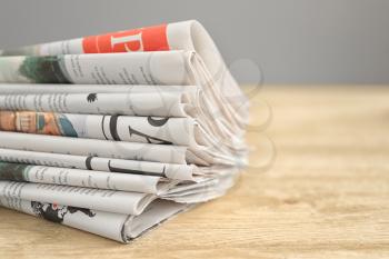 Folded newspapers wooden table, closeup�