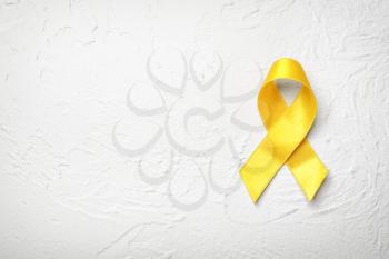 Yellow ribbon on light background. Cancer concept�