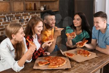 Young people having fun at party with delicious pizza indoors�