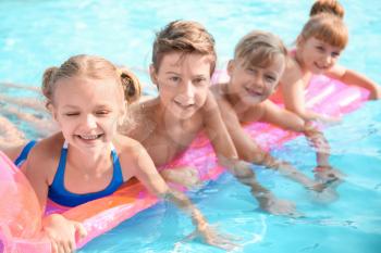 Cute children swimming in pool on summer day�
