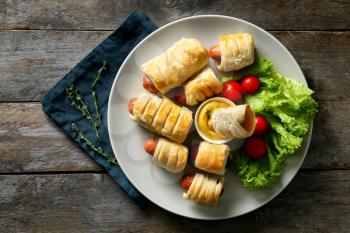 Tasty sausage rolls with fresh tomatoes on plate�