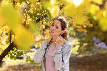 Sporty woman resting after training in autumn park�