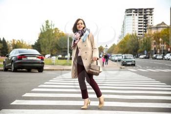 Beautiful fashionable woman crossing road�