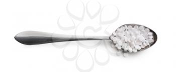 Metal spoon with stevia pills on white background�