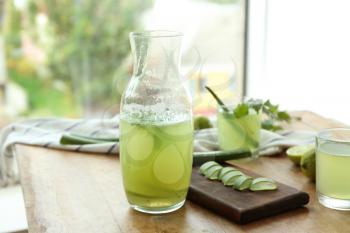 Jug of aloe vera cocktail on wooden table�