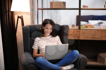 Young woman working with laptop at home�
