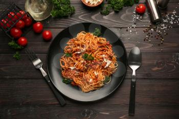 Plate with delicious pasta bolognese on dark wooden table�