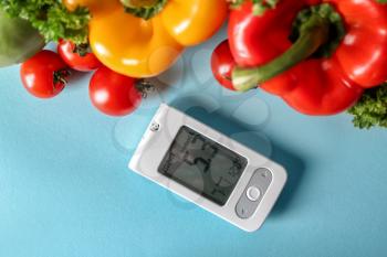 Digital glucometer with healthy food on color background. Diabetes diet�