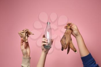 Many hands with different types of garbage on color background. Ecology concept�