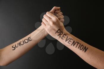 Female hands with text SUICIDE PREVENTION on dark background�