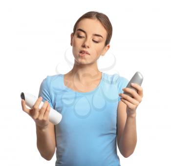 Young woman with different types of deodorant on white background�