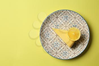 Piece of tasty lemon cake on color background�