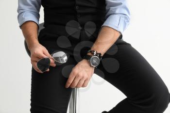 Stylish handsome man with sunglasses and watch on white background, closeup�