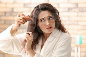 Woman with hair loss problem in bathroom�