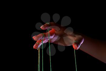 Hand of puppeteer on dark background�