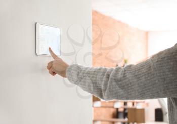 Young woman using application of smart home automation�