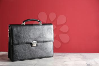 Male briefcase on table against color background�