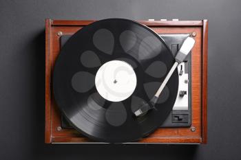 Record player with vinyl disc on dark background�