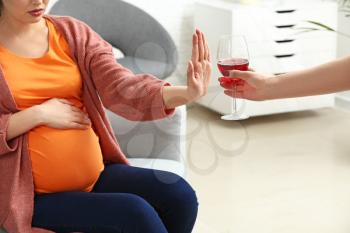 Pregnant woman rejecting alcohol at home�