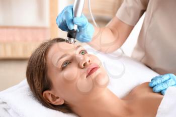 Young woman undergoing procedure of rf lifting in beauty salon�