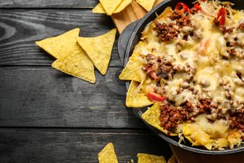 Tasty Mexican dish with nachos on table�