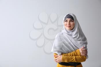 Beautiful Muslim woman on light background�