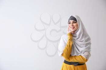 Beautiful Muslim woman on light background�