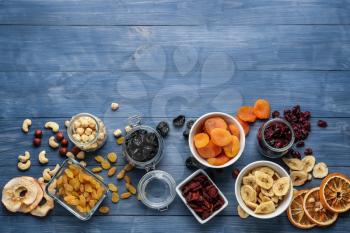Assortment of tasty dried fruits and nuts on wooden background�