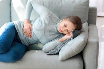 Young woman suffering from stomachache at home�