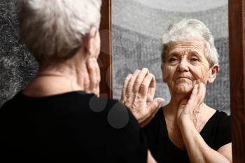 Senior woman looking in mirror�