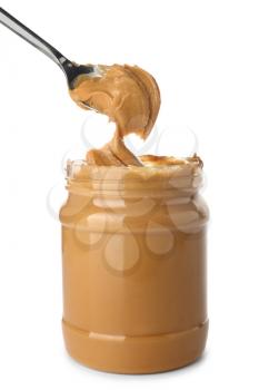 Taking of tasty peanut butter from jar on white background�